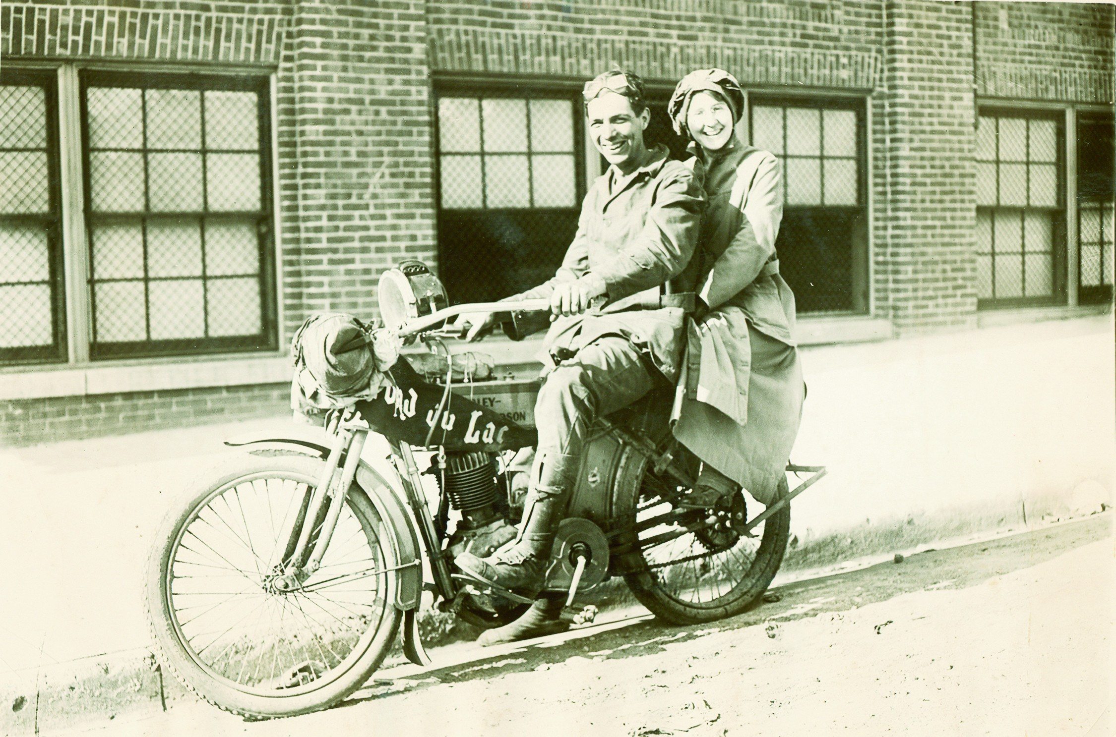 Old photo of a couple riding a Harley-Davidson Motorcycle